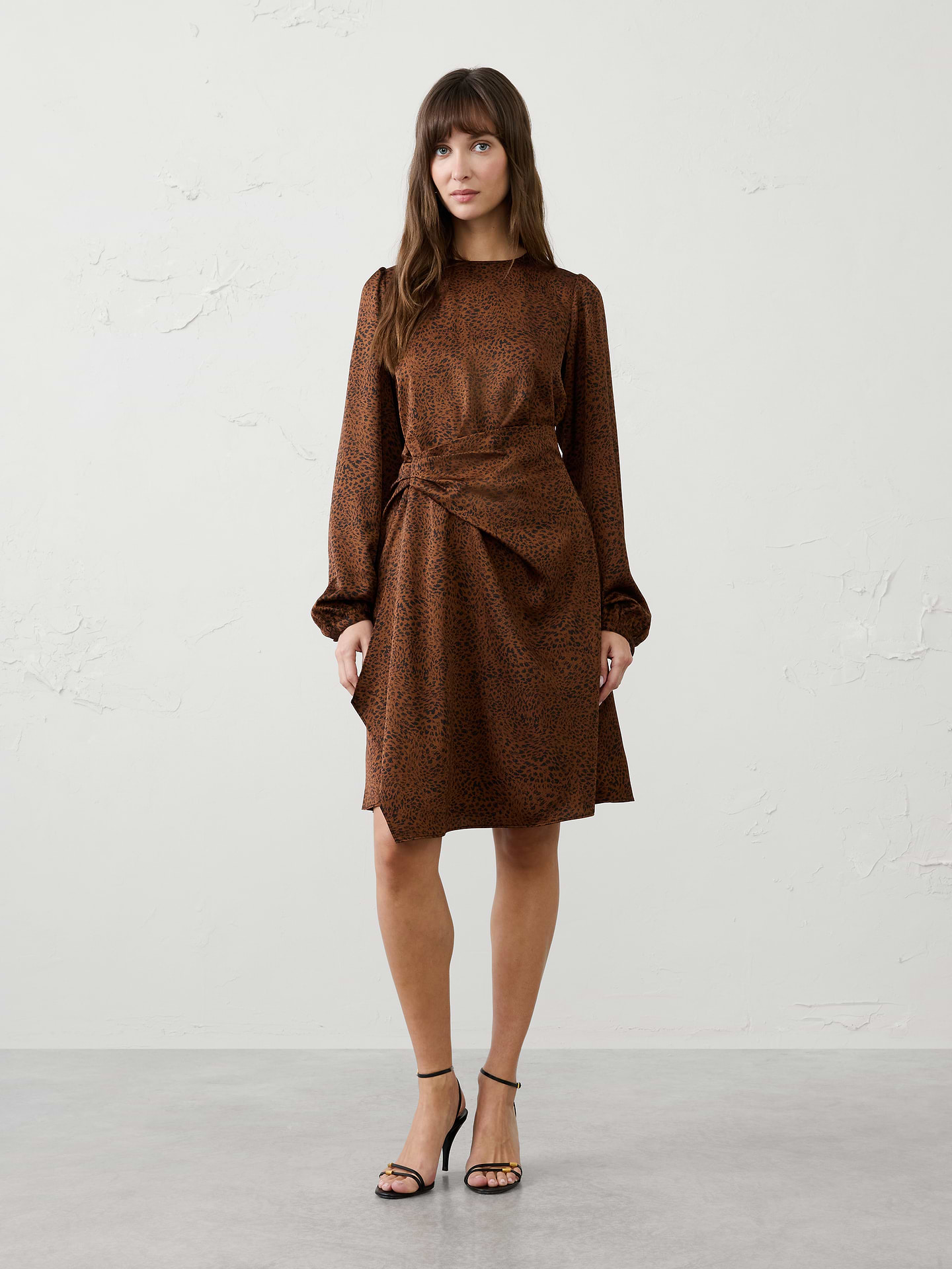 Image 1 of 4, Elegant asymmetric draping defines the waist while creating an effortlessly polished look for any occasion., Round neckline. Long sleeves with buttoned cuffs., Wrap-inspired skirt with cascading detail., Hidden back zipper closure., Back waist seam with back darts., Asymmetrical hem., Made exclusively for Banana Republic Factory., Product #1185674