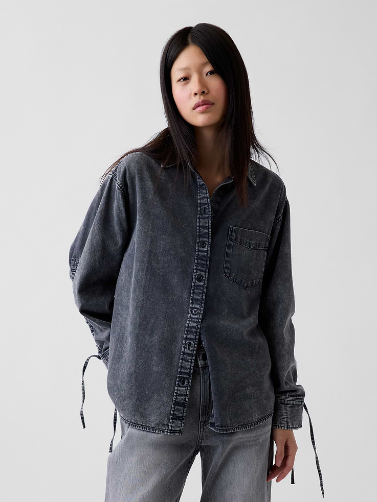 Image 1 of 5, Authentic, non-stretch denim button-up shirt. In an ultra oversized fit and longer length., Spread collar, button front., Long sleeves with drop shoulders, drawcords and ruching at button cuffs., Chest patch pocket., Back yoke seam., Shirttail hem., Black wash., Responsibly Made: This denim shirt is part of our water-saving Washwell program. Compared with conventional wash methods, Washwell uses at least 20% less water., More Sustainable Cotton: Made with 55% Protocol cotton verified by the U.S. Cotton Trust Protocol, a program which works with farms committed to improving their environmental footprint by minimizing water usage and improving soil health (Claim No. 10127)., Product #1184797