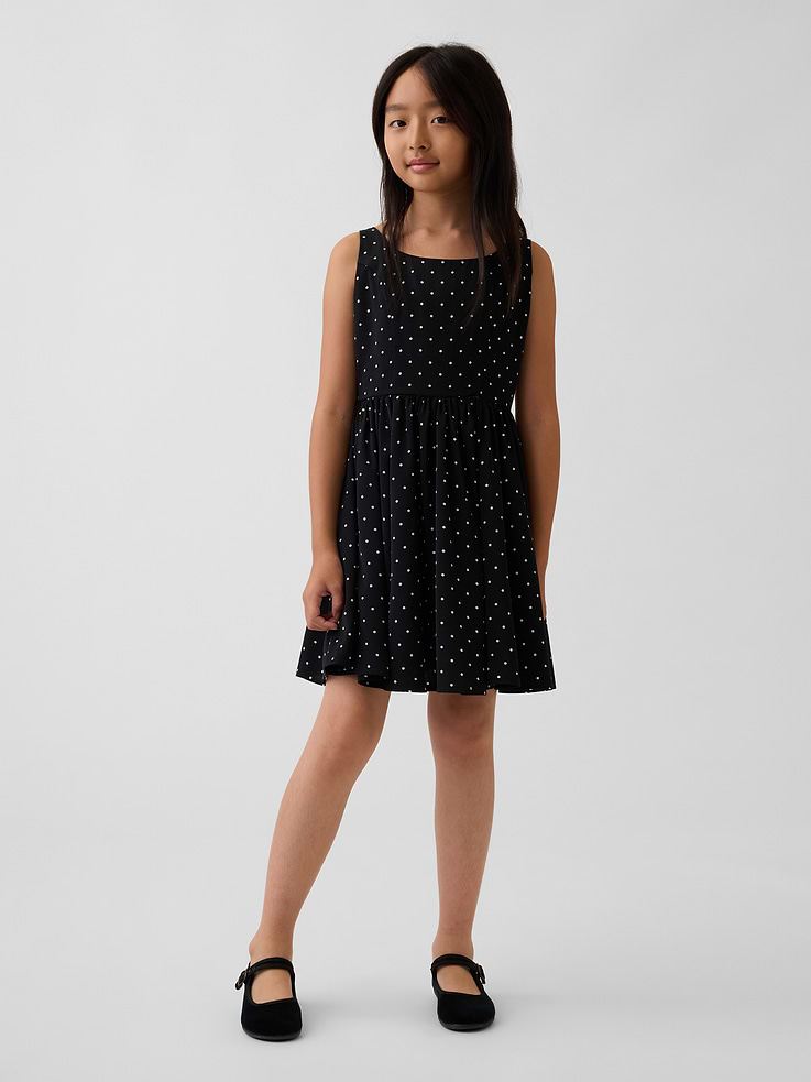 Image 1 of 5, Smooth satin kids tank dress., Square neck., Tank straps., Smocked panel at back bodice., Shirring at waist seam., Allover polka dot print., This product was made in a factory that invests in gender equity and women’s empowerment through RISE. Learn more at gapinc.com/equity ., Product #1189066