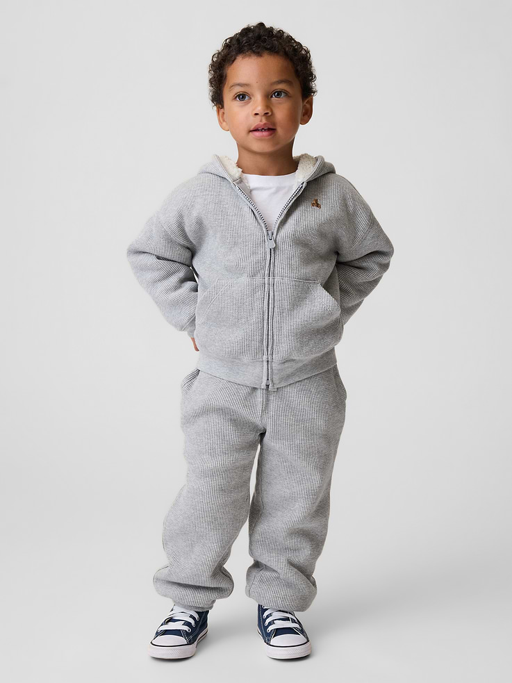 Image 1 of 4, Soft waffle-knit cotton joggers with a cozy sherpa lining., Elasticized rib waist with drawcords., Side on-seam pockets., Elasticized cuffs., Sherpa lining made with 100% recycled polyester. Compared to virgin materials, using recycled materials helps reduce resource use and waste., This product was made in a factory that invests in gender equity and women’s empowerment through RISE. Learn more at gapinc.com/equity ., Product #1184878