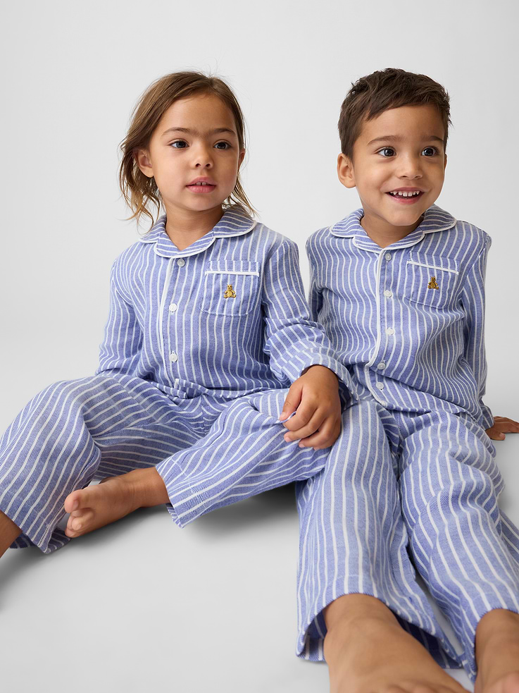 Image 1 of 6, Soft, brushed flannel pajama shirt and pants PJ set., Notch collar, button front., Long sleeves., Chest patch pocket with embroidered Brannan Bear., Piping detail at edges., Elasticized waist at PJ pants., Allover print., Made with 100% recycled polyester. Compared to virgin materials, using recycled materials helps reduce resource use and waste., Shop matching PJs for all., This product was made in a factory that invests in gender equity and women’s empowerment through RISE. Learn more at gapinc.com/equity ., Product #1180435