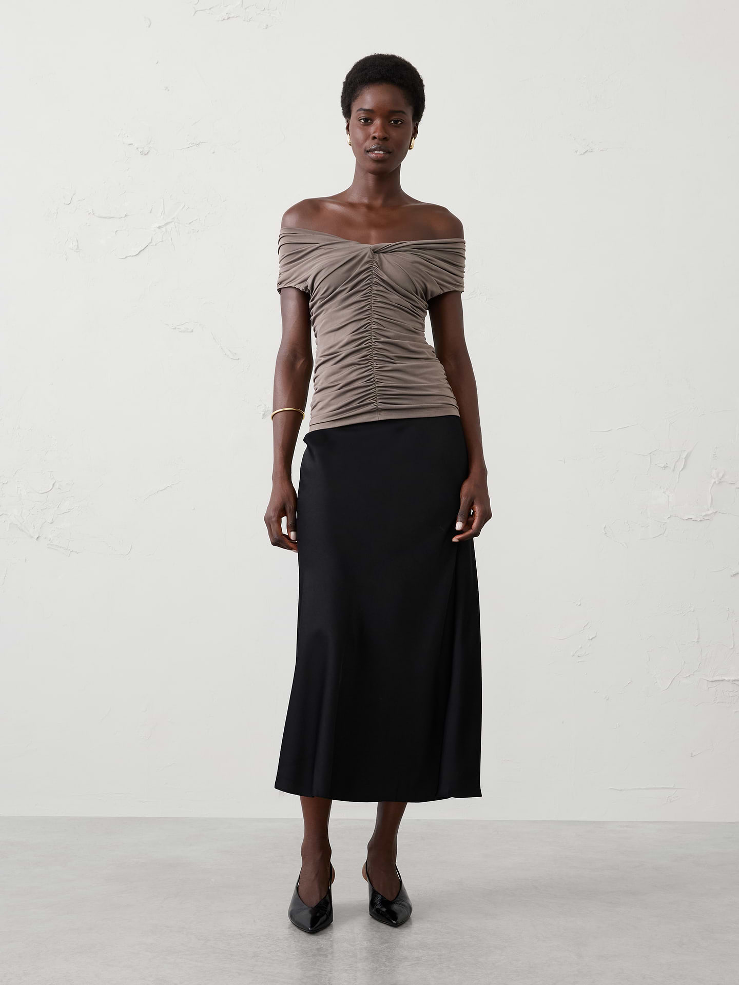 Image 1 of 3, Crafted from a sleek jersey fabric with a silk‑like hand feel and matte finish, this top offers exceptional stretch and beautiful drape. Front ruching creates a flattering silhouette, while the comfortable fabric makes it an easy, elevated option for dressier occasions., Off‑the‑shoulder sweetheart neckline. Cap sleeves., Fitted at the waist., Center front and back ruching., Side seam gathering., Made exclusively for Banana Republic Factory., Product #1185987