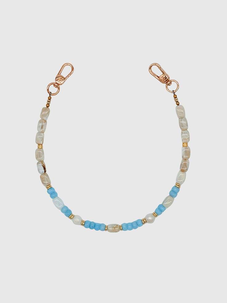 Image 1 of 1, Soft, coastal tones meet natural elegance., The Sora Strap is handcrafted with a refined mix of large freshwater pearl beads, acrylic marble beads, blue jade rondelles, and gold spacer accents, creating a look that feels both effortless and elevated., The neutral marble tones paired with cool jade hues make this piece versatile and timeless., Universal Phone Hitch required to attach to your phone case, sold separately., Over time, certain bead colors may lose their vibrancy due to exposure to air, water, and heat, which can result in fading, tarnishing, or rubbing off., Due to natural variations in gemstones and beads, product may differ slightly from displayed photos., THE CÆP in no way guarantees the integrity of your smartphone or screen when using this strap. Handle with care and employ your cell phone at your own risk.