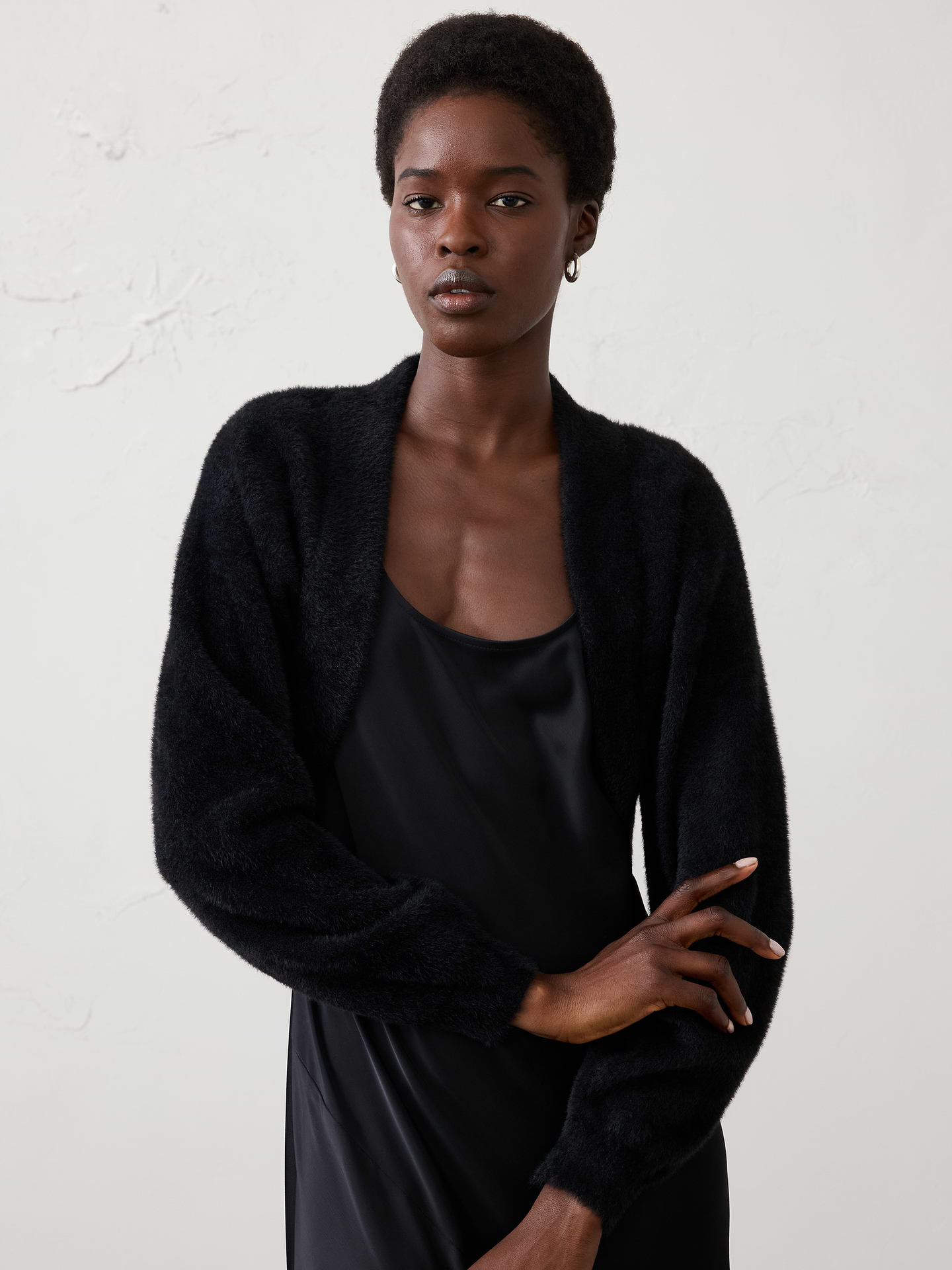 Image 1 of 4, Made from our plush eyelash yarn, this shrug offers a luxuriously soft hand feel with a light, fuzzy texture. The easy silhouette is perfect for layering over dresses and tops, adding warmth and softness without feeling bulky., Open‑front design. Long sleeves., Drop shoulders., Care suggestion: Use a low‑heat iron; steam as needed., Made exclusively for Banana Republic Factory., Product #1177092