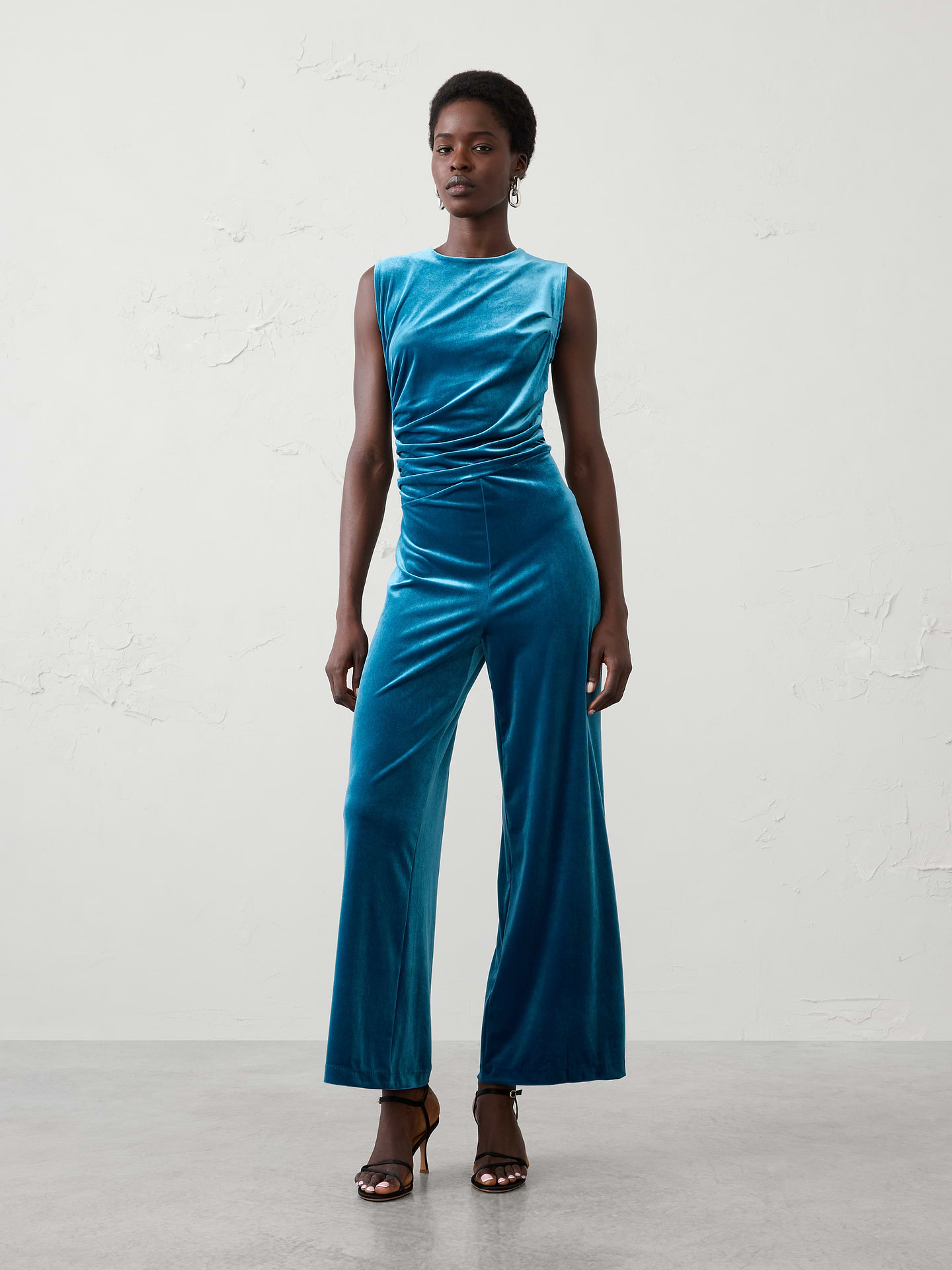 Image 1 of 4, Make every occasion feel special in this velvet draped jumpsuit, crafted from soft knit velvet. Whether styled for holiday parties, dinners, or evening celebrations, this one-and-done statement piece brings timeless glamour to any event., Crew neck. Sleeveless., Draped bodice., Tailored waist., Hidden back zipper closure., Made exclusively for Banana Republic Factory., Product #1185683