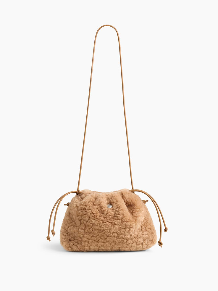 Image 1 of 6, Soft sherpa pouchette bag., Worn hand-held, crossbody or over-the-shoulder., Vegan leather shoulder strap., Drawcord closure at top., Product #1186132