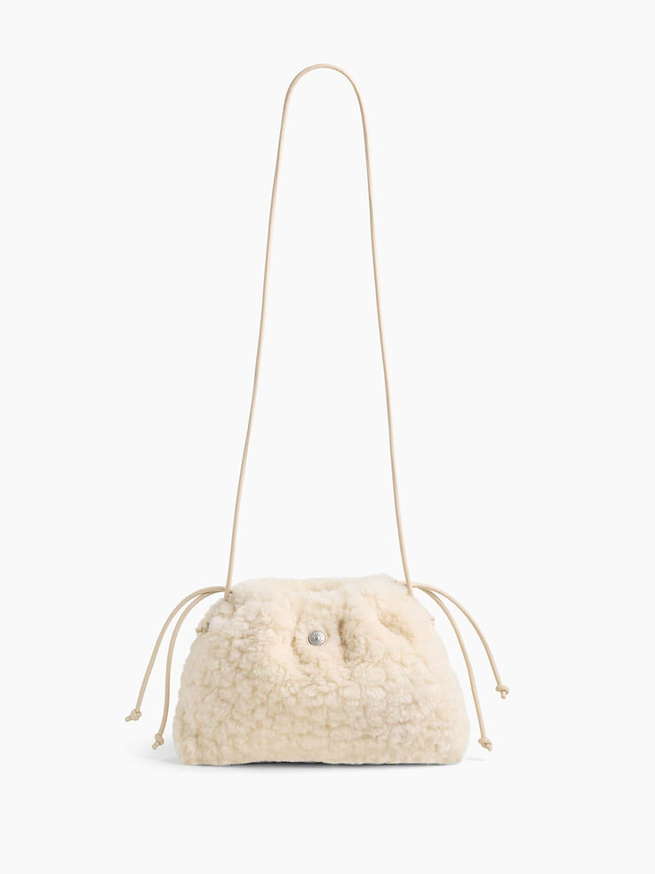 Image 1 of 6, Soft sherpa pouchette bag., Worn hand-held, crossbody or over-the-shoulder., Vegan leather shoulder strap., Drawcord closure at top., Product #1186132