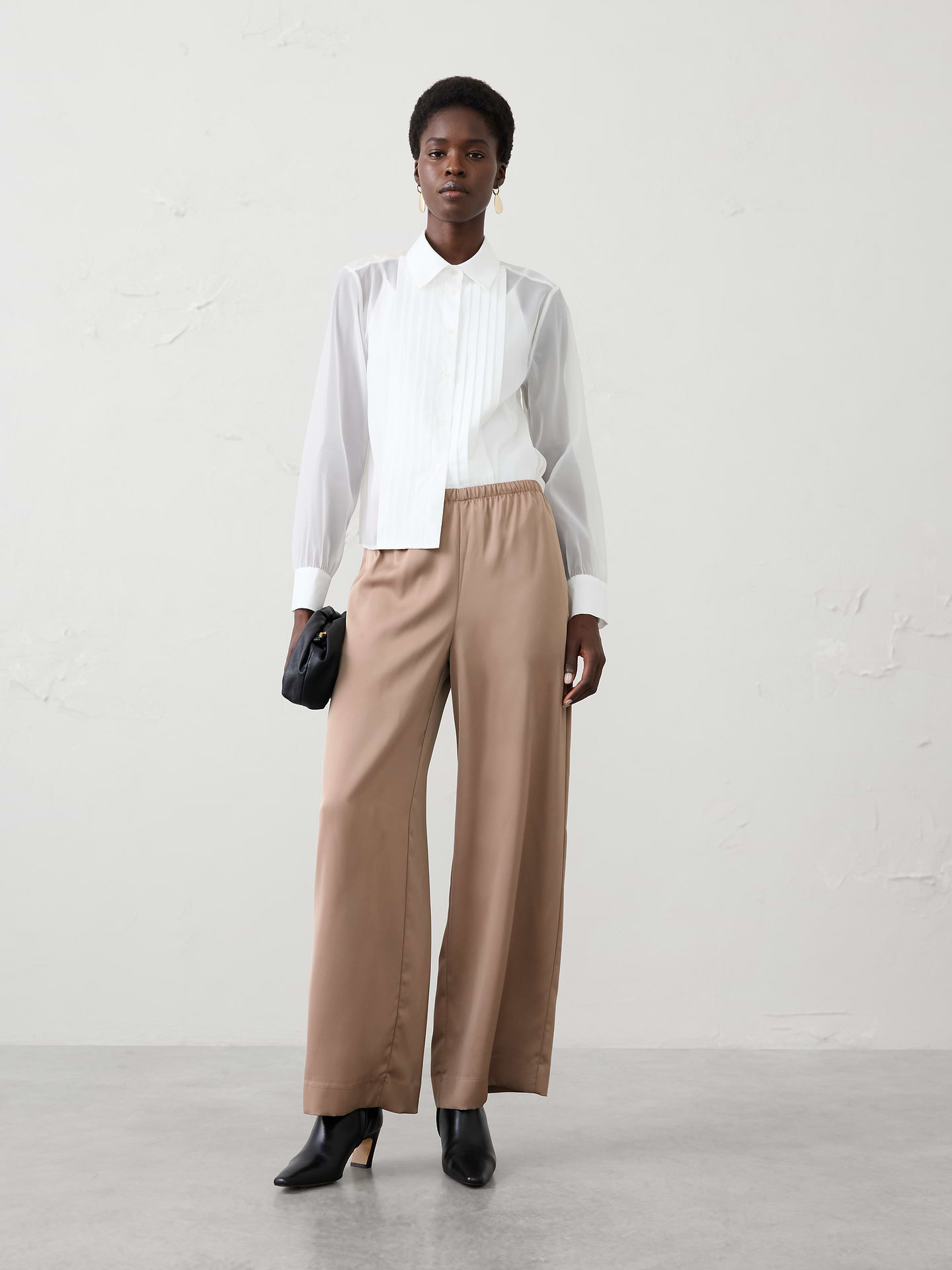 Image 1 of 3, Effortlessly elegant and endlessly versatile, our satin pant is designed to take you from casual gatherings to special occasions with ease. Crafted from lightweight satin fabric with a fluid drape and subtle sheen. The pull-on design offers effortless wear, while the clean, streamlined look makes it easy to dress up with heels for a party or pair with a cozy sweater and flats for a more relaxed approach., Pull-on pant. Elasticized waistband., Relaxed wide-leg silhouette., Made exclusively for Banana Republic Factory., Product #1182237