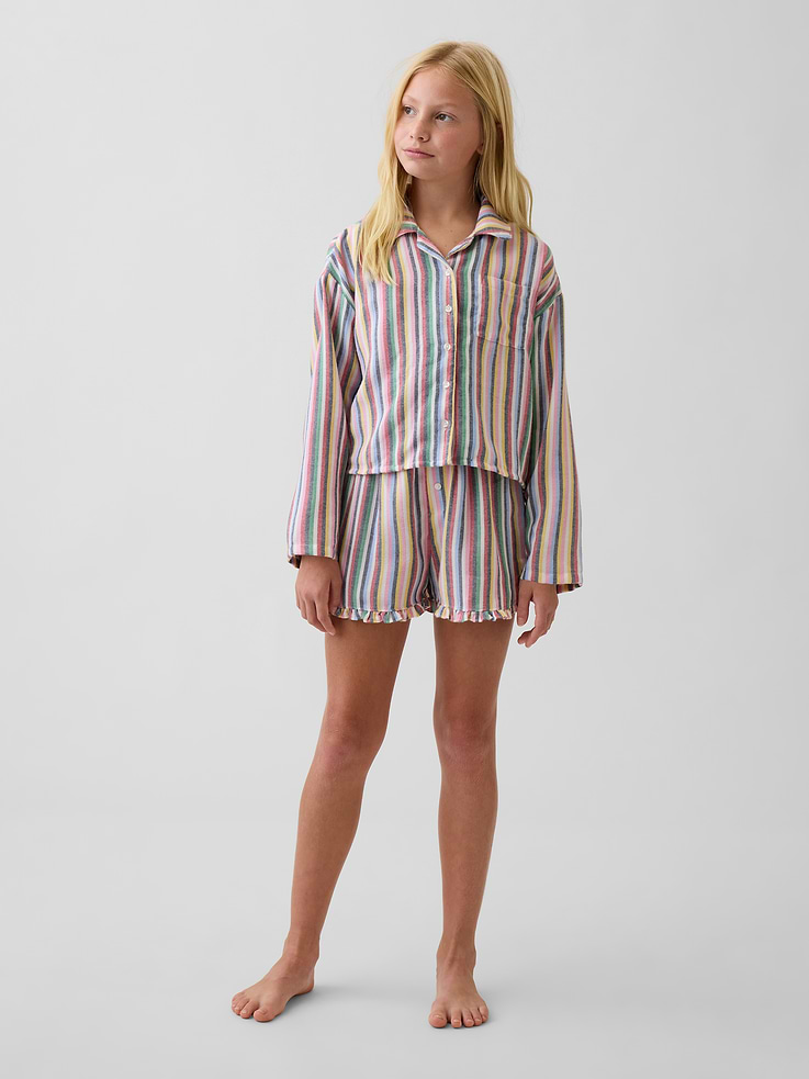 Image 1 of 4, Soft flannel pajama shirt and shorts PJ set., Notch collar, button front., Long sleeves with drop shoulders., Chest patch pocket., Elasticized waist with faux button fly at PJ shorts., Ruffle trim at hem., Allover plaid or Happy Stripe print., Made with 100% recycled polyester. Compared to virgin materials, using recycled materials helps reduce resource use and waste., Shop matching PJs for all., This product was made in a factory that invests in gender equity and women’s empowerment through RISE. Learn more at gapinc.com/equity ., Product #915897