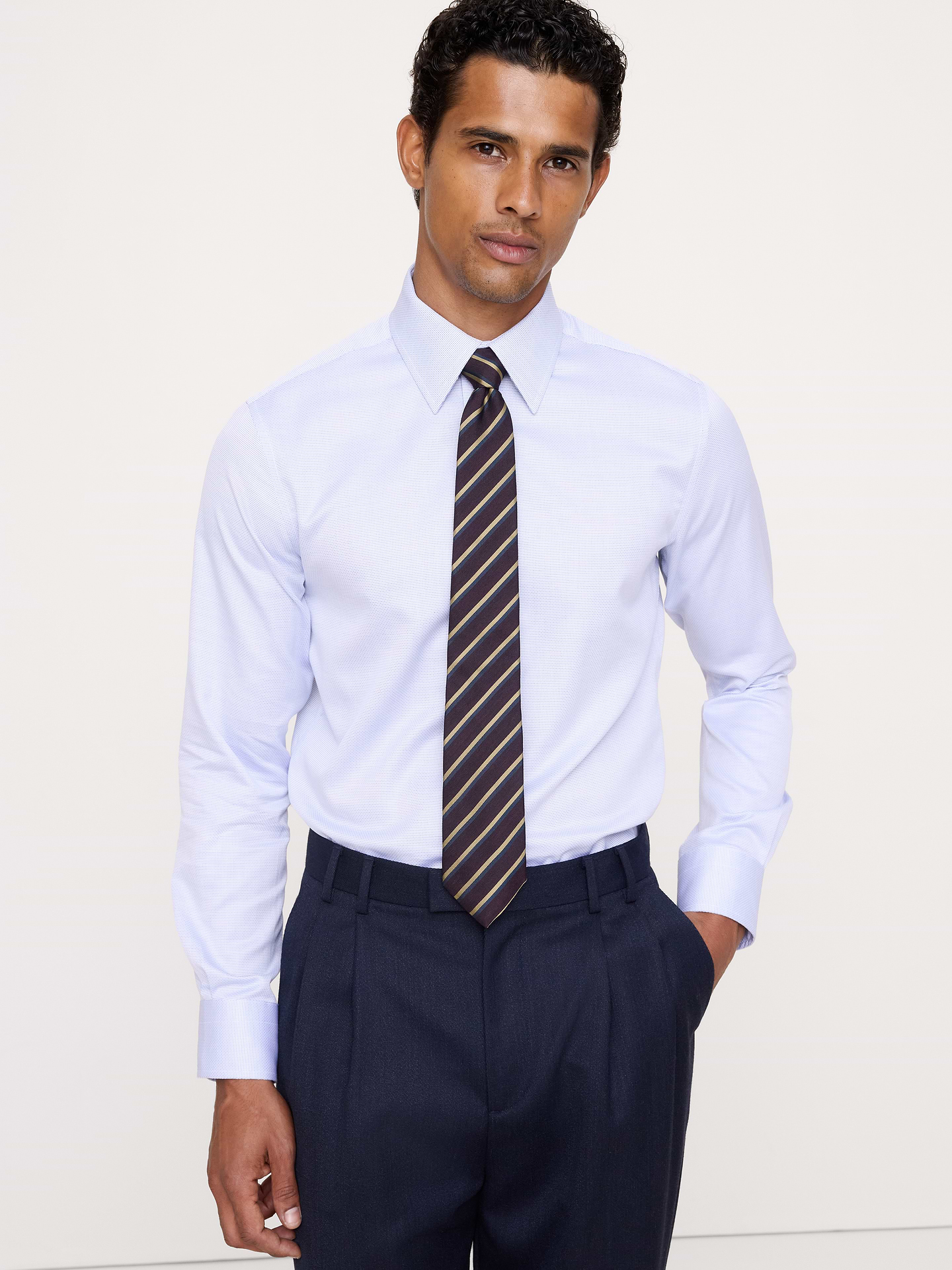 Image 1 de 8, Conçue pour être facile à porter et à entretenir, cette chemise habillée élégante est confectionnée dans une popeline de coton spéciale dotée de la technologie de coton PUREPRESS™, un procédé qui lisse et protège le tissu pour un fini infroissable ., Coupe ajustée. Silhouette droite et près du corps., Col italien; devant boutonné., Pan de chemise arrondi., Produit #860786