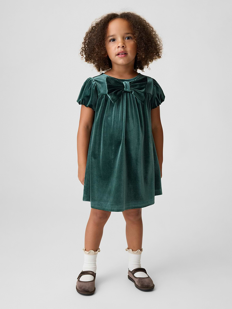 Image 1 of 4, Soft, stretch velour knit dress., Round neck with back button placket., Lawn-lined puff sleeves with elasticized openings., Bow detail at front., This product was made in a factory that invests in gender equity and women’s empowerment through RISE. Learn more at gapinc.com/equity ., Product #1185566