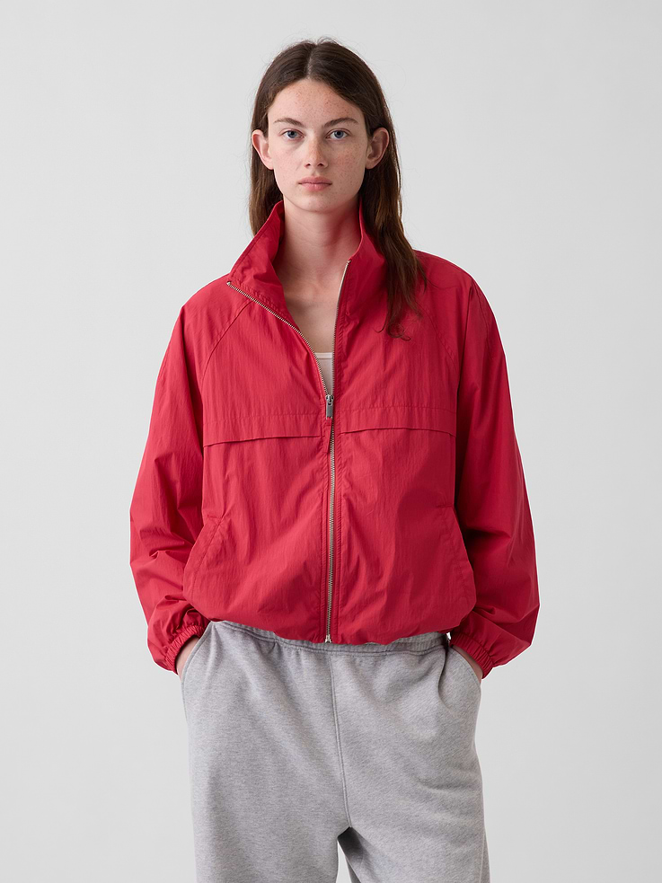 Image 1 of 5, Crinkle cotton-nylon poplin track jacket. In an oversized fit and slightly cropped length., Mockneck, zipper front., Long raglan sleeves with elasticized cuffs., Front welt pockets., Bungee hem., This product was made in a factory that invests in gender equity and women’s empowerment through RISE. Learn more at gapinc.com/equity ., Product #1186874
