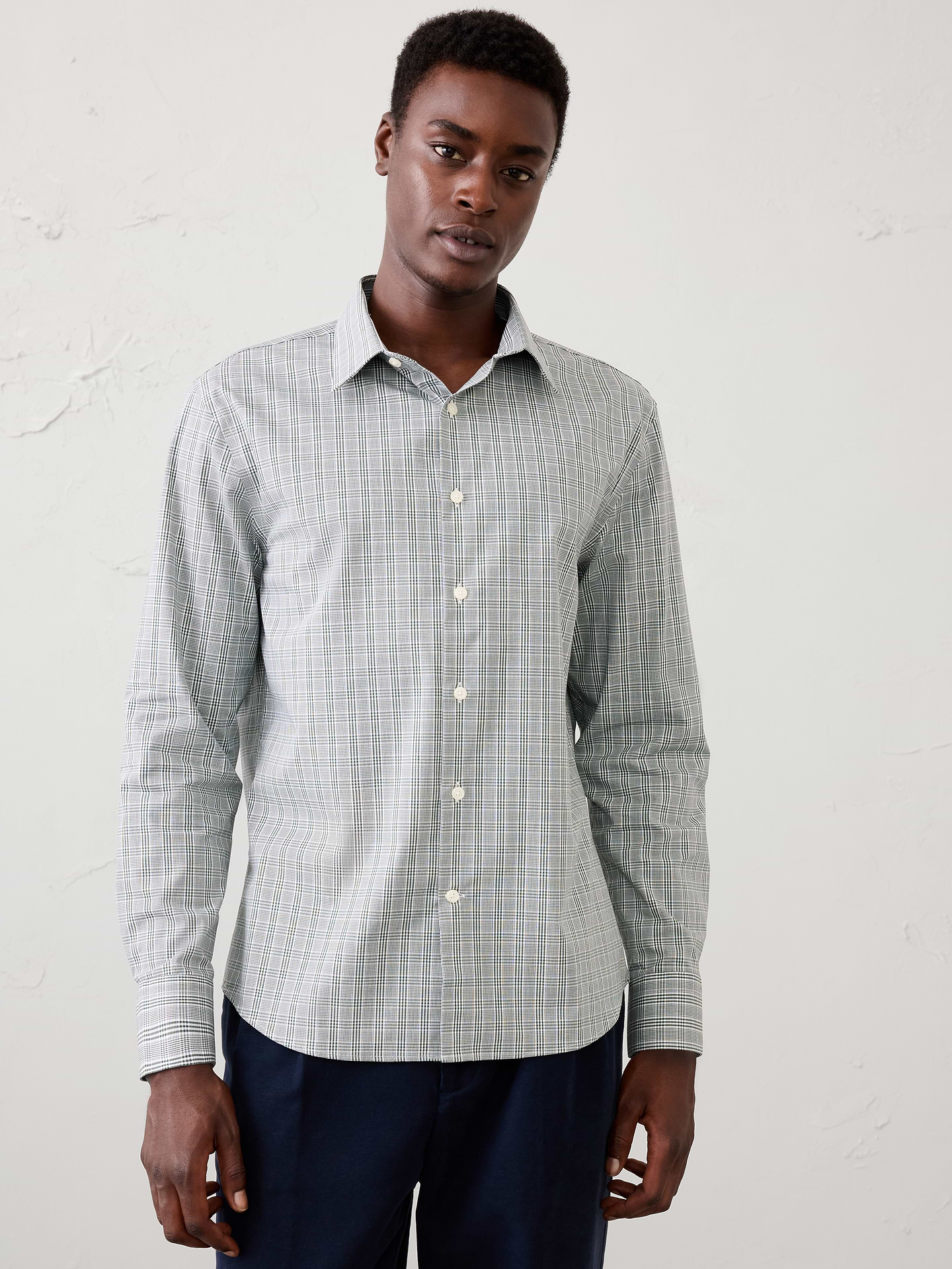 Image 1 of 7, WRINKLE RESISTANT: No need to iron, these soft, cotton dress shirts are specially engineered to resist wrinkles so it stays looking crisp and pulled-together., UNTUCKED: Designed with a shorter hemline to hit right at the hips., Spread collar. Long sleeves with adjustable double-button barrel cuffs and button vents., Clean front., Shirttail hem., Made exclusively for Banana Republic Factory., Product #1175947