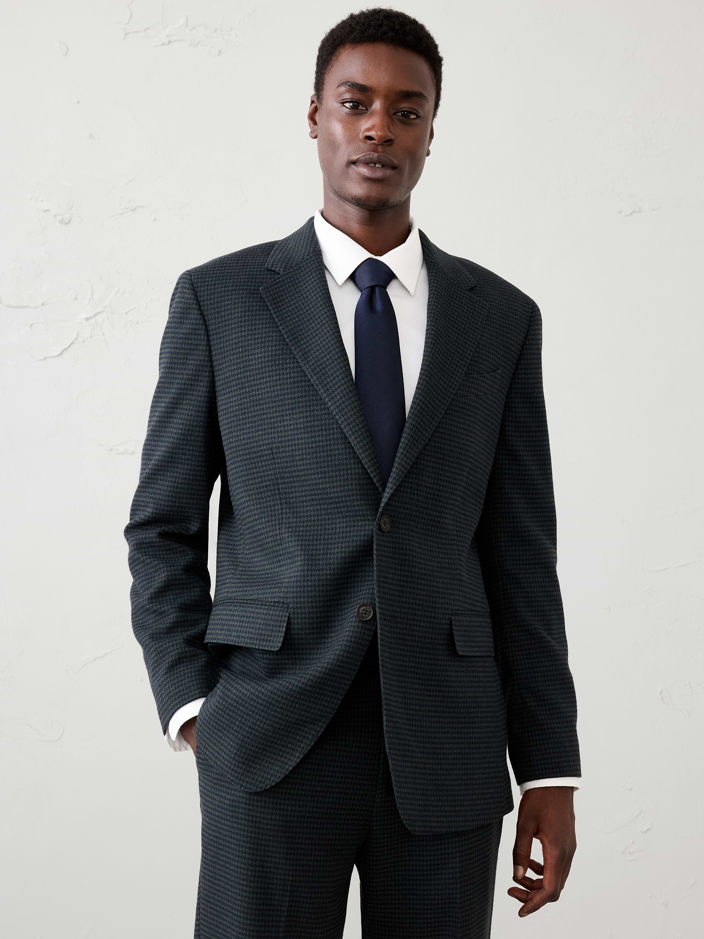 Image 1 of 3, Crafted in a rich walnut brown houndstooth, this jacket offers a warm, heritage‑inspired take on classic tailoring. The timeless pattern and refined texture create depth and visual interest while remaining easy to wear. Designed with a polished silhouette, it transitions seamlessly from occasion dressing to elevated everyday styling, whether paired with the matching trouser or worn as a standout separate., Notch collar with button hole on wearers left panel. Four non-functioning buttons at cuffs., Two-button front closure., Front pockets. Chest pocket., Internal pockets., Double back vent., Fully lined., Matching suit trouser available., Wear it as a full suit or break it apart to maximize versatility., Made exclusively for Banana Republic Factory., Product #1179683