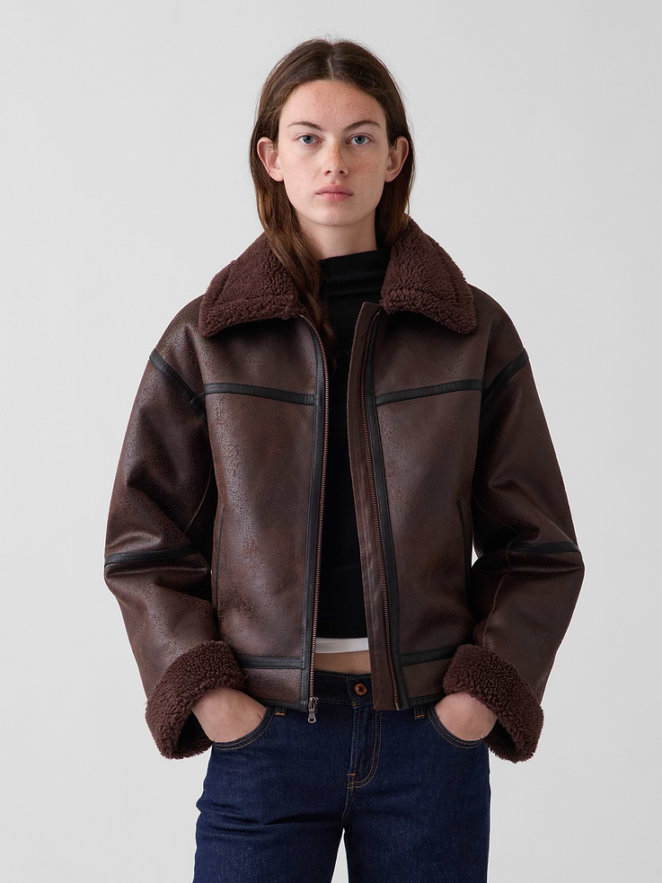 Image 1 of 6, Distressed vegan leather flight jacket with bonded sherpa detailing. In a relaxed fit., Sherpa spread collar., Long sleeves with drop shoulders and sherpa cuffs., Zipper front., Front slant welt pockets., Contrast vegan leather trim., This product was made in a factory that invests in gender equity and women’s empowerment through RISE. Learn more at gapinc.com/equity ., Product #1184881