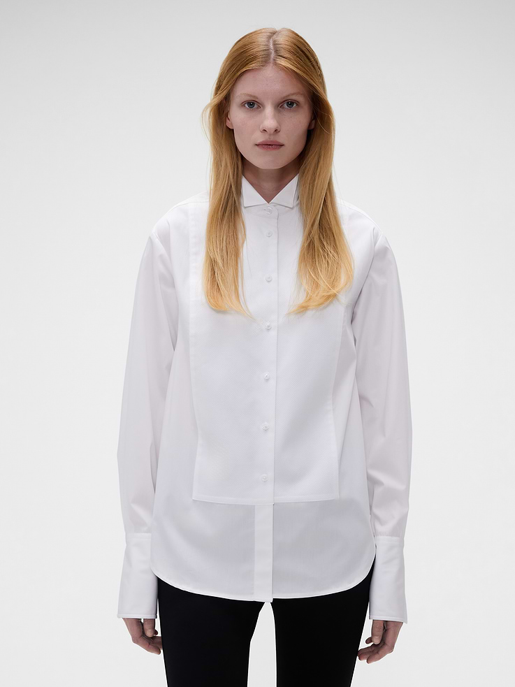 Image 1 of 9, Crisp cotton poplin tuxedo shirt. In a classic fit., Wing collar., Long sleeves with textured inner cuffs., Hidden button closure with Gap x Victoria Beckham logo patch., Textured bib front., Made with 100% organically grown cotton which is grown without the use of synthetic pesticides and fertilizers., Product #1183573