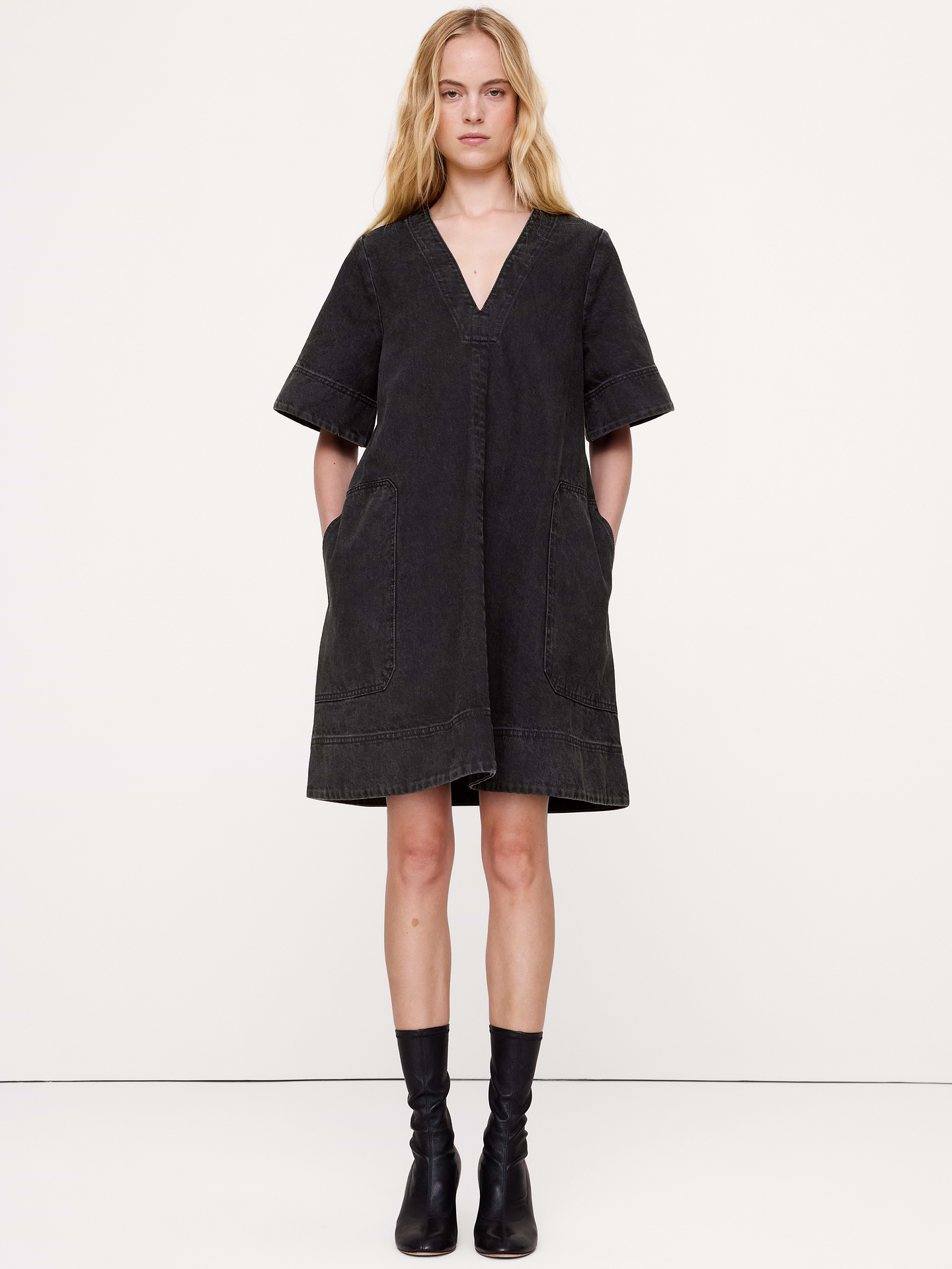 Image 1 of 8, Your new partner in crime, this denim mini dress is finished with a garment wash for already-loved softness and lived-in color., Trapeze Fit: Straight through the bust and waist, A-line skirt., V-neck., Side seam pockets., Unlined., Product #873257