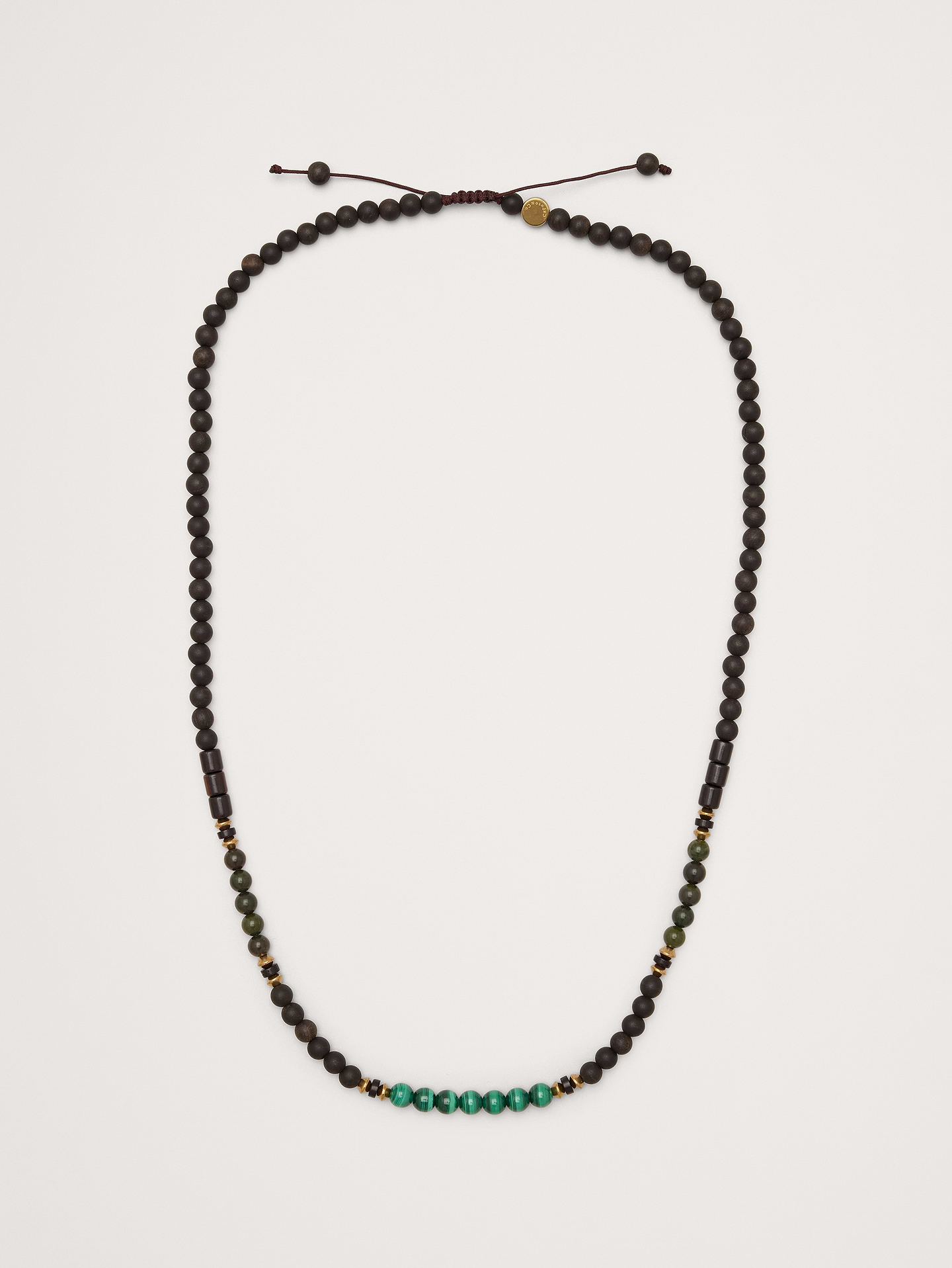 Image 1 of 3, An adjustable necklace with wooden beads accented with malachite, green African jasper, and brass spacers., Caputo & Co: Modern artisanal accessories that marries American soul with Central American heart. Handcrafted sterling silver, premium gemstones, and quality leathers., Adjustable pull-cord closure., Product #1200076