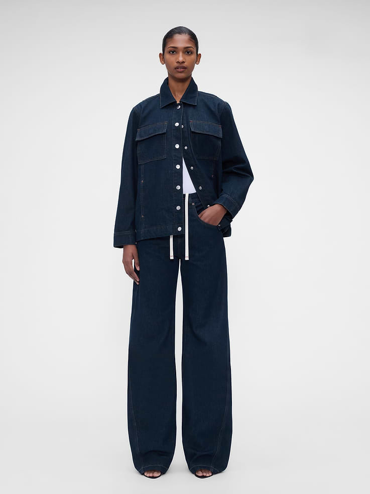 Image 1 of 10, Fit: A full-length baggy jean that's fitted on the waist & relaxed all the way down., Fabric: 95% Cotton, 5% Recycled Cotton., No Stretch: Rigid Jeans. Authentic denim that gets better with every wear. Made to wear all day & break in over time. ​, Rise: Cinched for high rise or worn loose for a low slung look., Inseam: 30.5” longer inseam., Look: A five-pocket baggy jean designed to pool with flats or hit below the ankle in heels., Details: Button closure, zip fly, drawstrings at inner waistband, five-pocket styling, red stitching, rinse wash, & Gap × Victoria Beckham logo leather patch at back., Responsibly Made: This jean is part of our water-saving Washwell program. Compared with conventional wash methods, Washwell uses at least 20% less water., More Sustainable Cotton: Made with 5% recycled cotton. Compared to virgin materials, using recycled materials helps reduce resource use and waste., Product #1185492