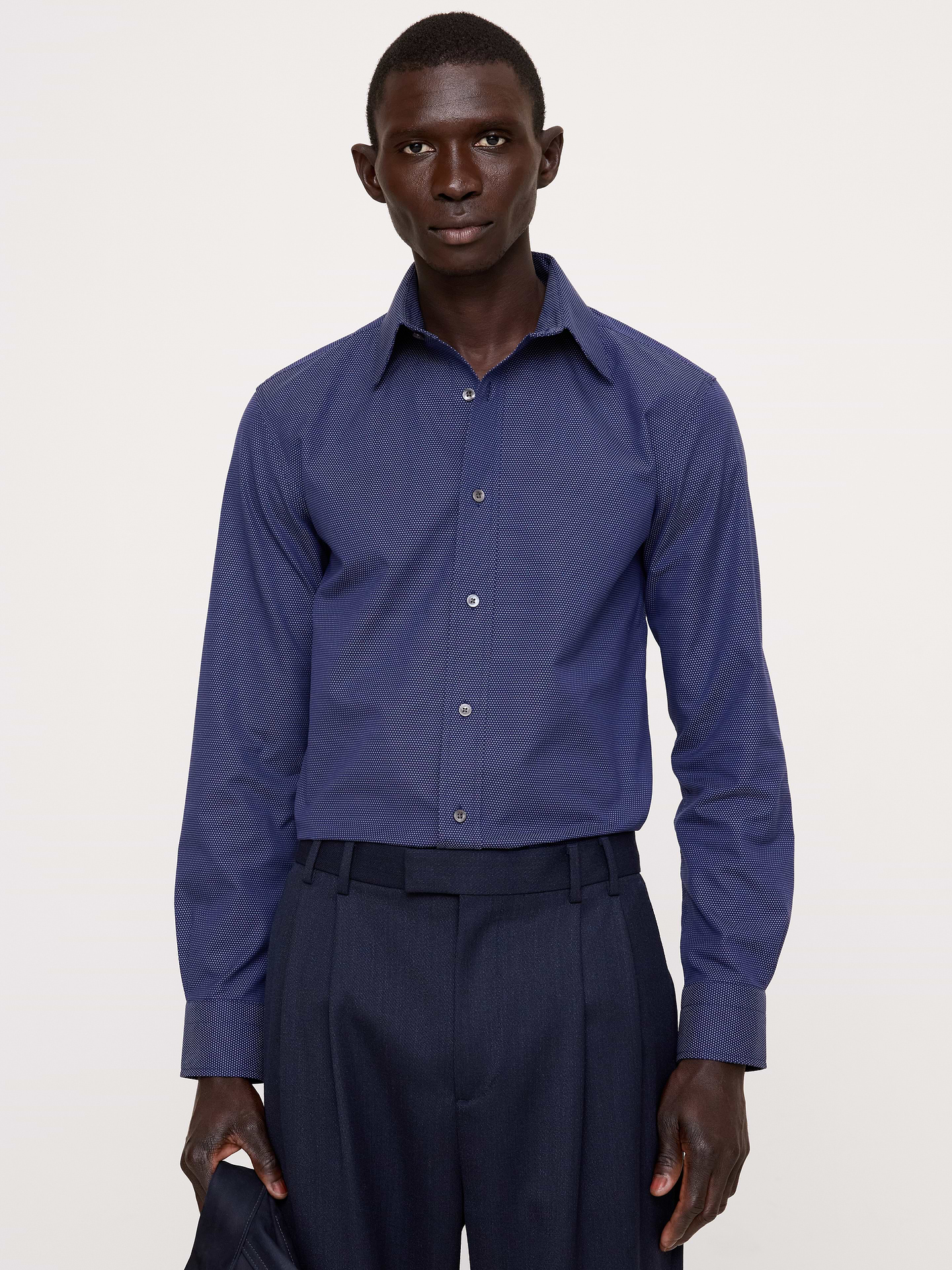 Image 1 de 8, Conçue pour être facile à porter et à entretenir, cette chemise habillée élégante est confectionnée dans une popeline de coton spéciale dotée de la technologie de coton PUREPRESS™, un procédé qui lisse et protège le tissu pour un fini infroissable ., Coupe ajustée. Silhouette droite et près du corps., Col italien; devant boutonné., Pan de chemise arrondi., Produit #860786