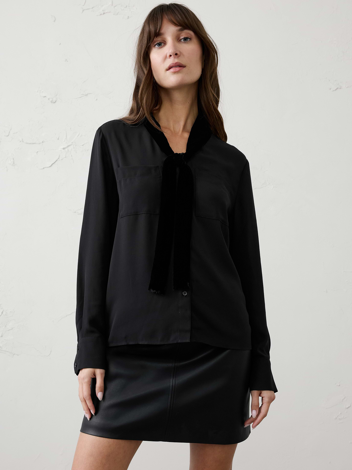 Image 1 of 1, Elevate your holiday wardrobe with this sophisticated blouse, designed with an elegant velvet scarf detail that drapes effortlessly at the neckline. The relaxed silhouette and fluid woven body create an easy, polished look, while tailored cuffs and utility-inspired chest pockets add a modern touch. Refined yet versatile, it's the perfect piece for festive gatherings, special occasions, and elevated everyday dressing., V-neckline with attached velvet scarf. Long sleeves with wide buttoned cuffs., Button‑front closure., Dual chest patch pockets., Back yoke with center box pleat., Made exclusively for Banana Republic Factory., Product #1185903