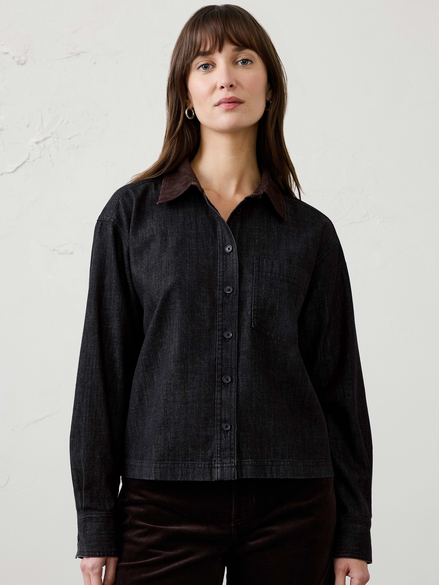 Image 1 of 4, A fresh take on a classic denim shirt, this contrast-collar cropped shirt combines heritage-inspired details with modern proportions. Crafted in denim with a contrasting corduroy collar and cuff accents, it brings rich texture and dimension to everyday dressing., Contrast corduroy collar. Long sleeves with button cuffs., Button-front closure., Chest pocket., Back yoke with center box pleat., Made exclusively for Banana Republic Factory., Product #1185921