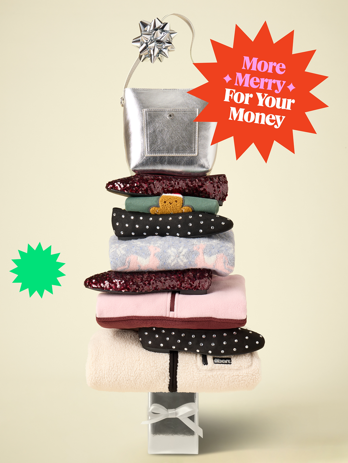 Tower of folded winter clothes and accessories topped with a silver purse on a wrapped gift; starburst reads “More Merry For Your Money.”