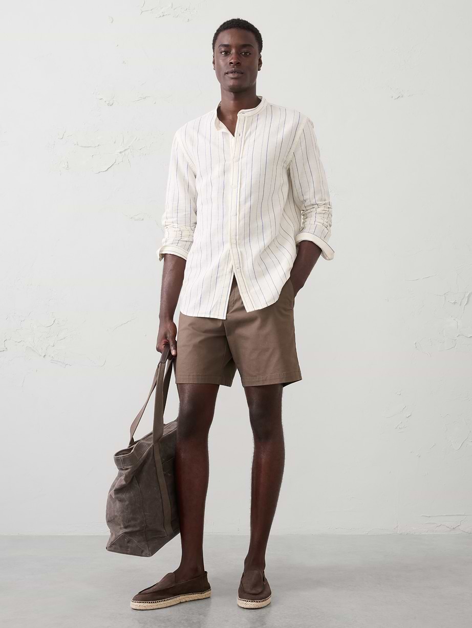 Man in white shirt, tan shorts, and shoes.