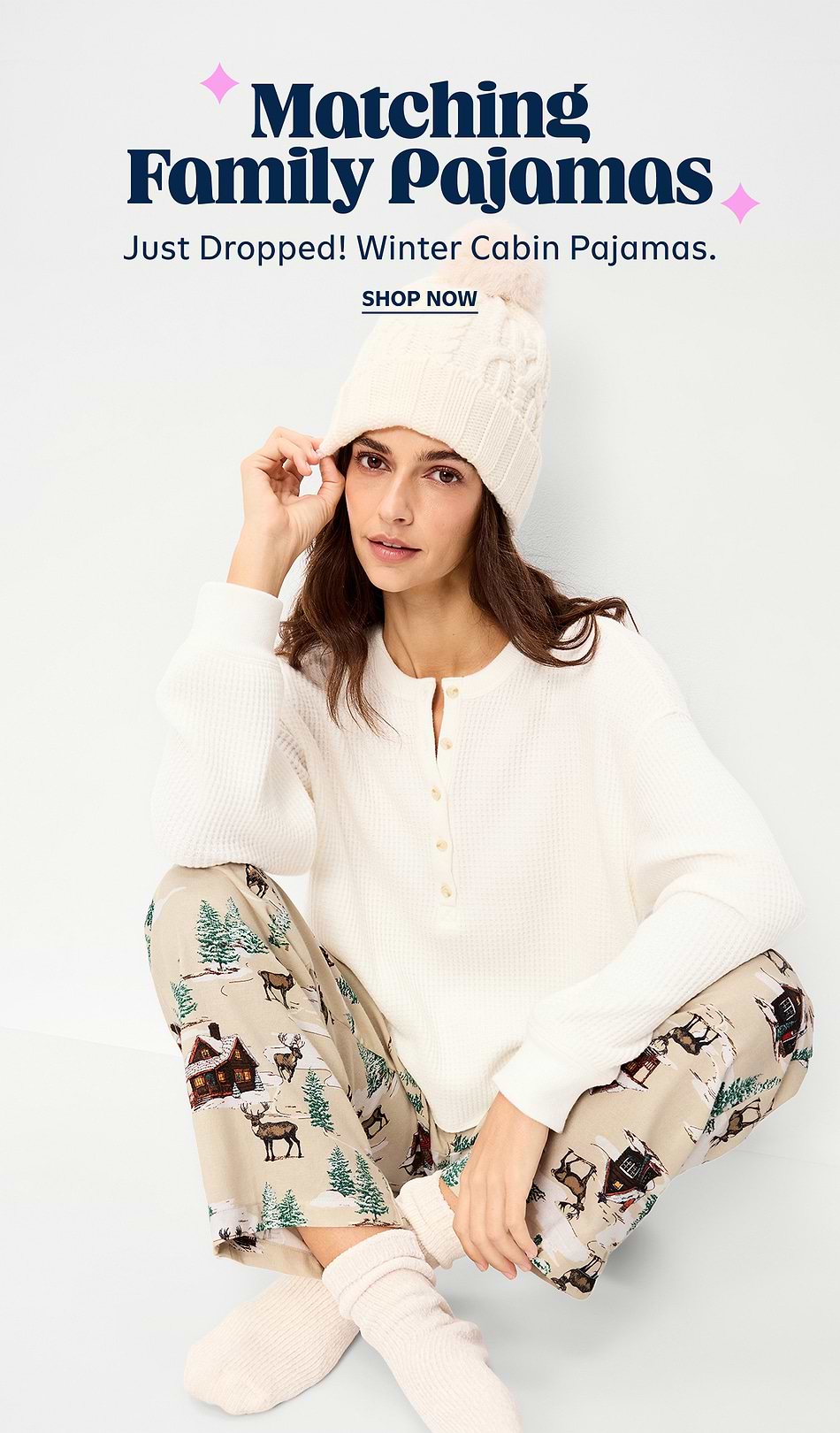 Ad for Matching Family Pajamas: person in a white knit top and beanie wears beige pajama pants with winter cabin and deer print; text reads “Just Dropped! Winter Cabin Pajamas. Shop Now.”