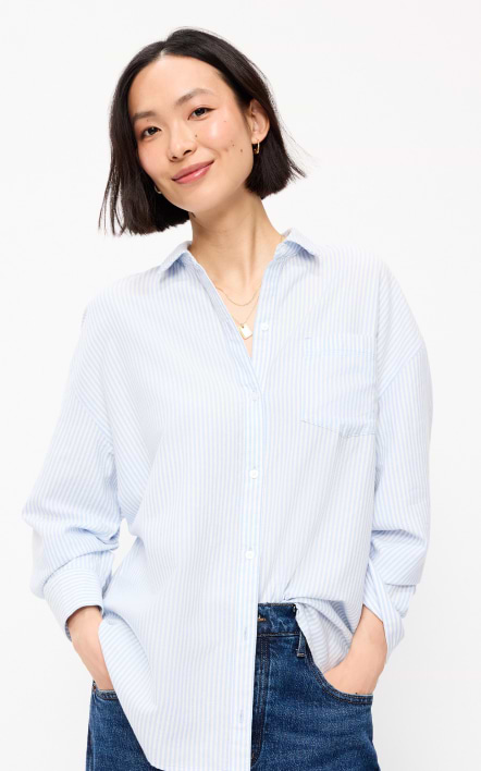 A female model wearing a light blue striped button-down shirt.