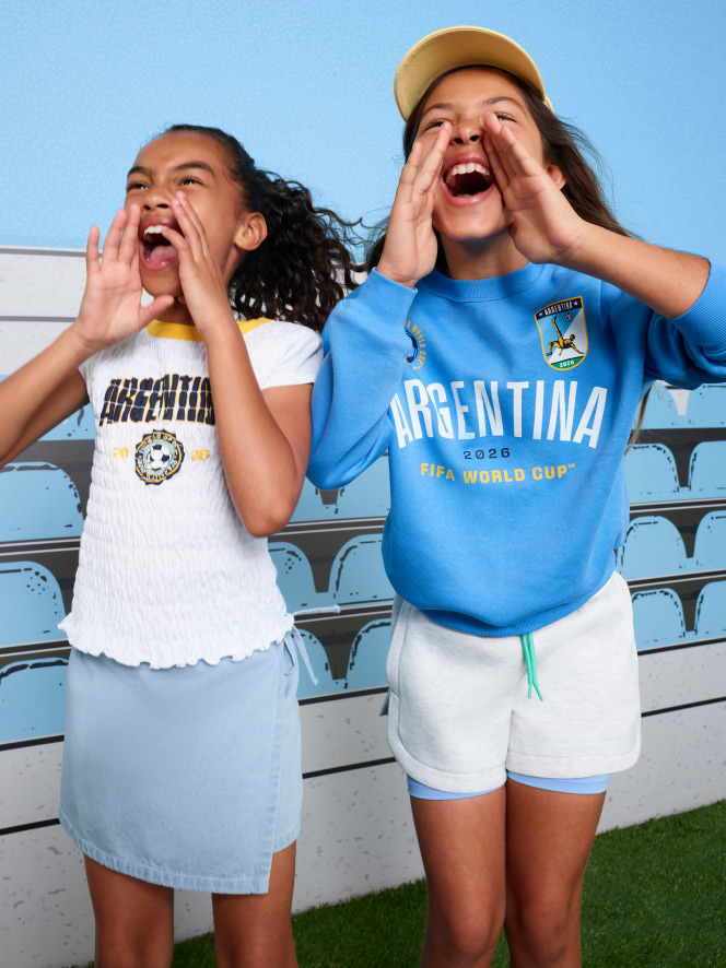 Two young female models wearing world cup soccer jerseys. 