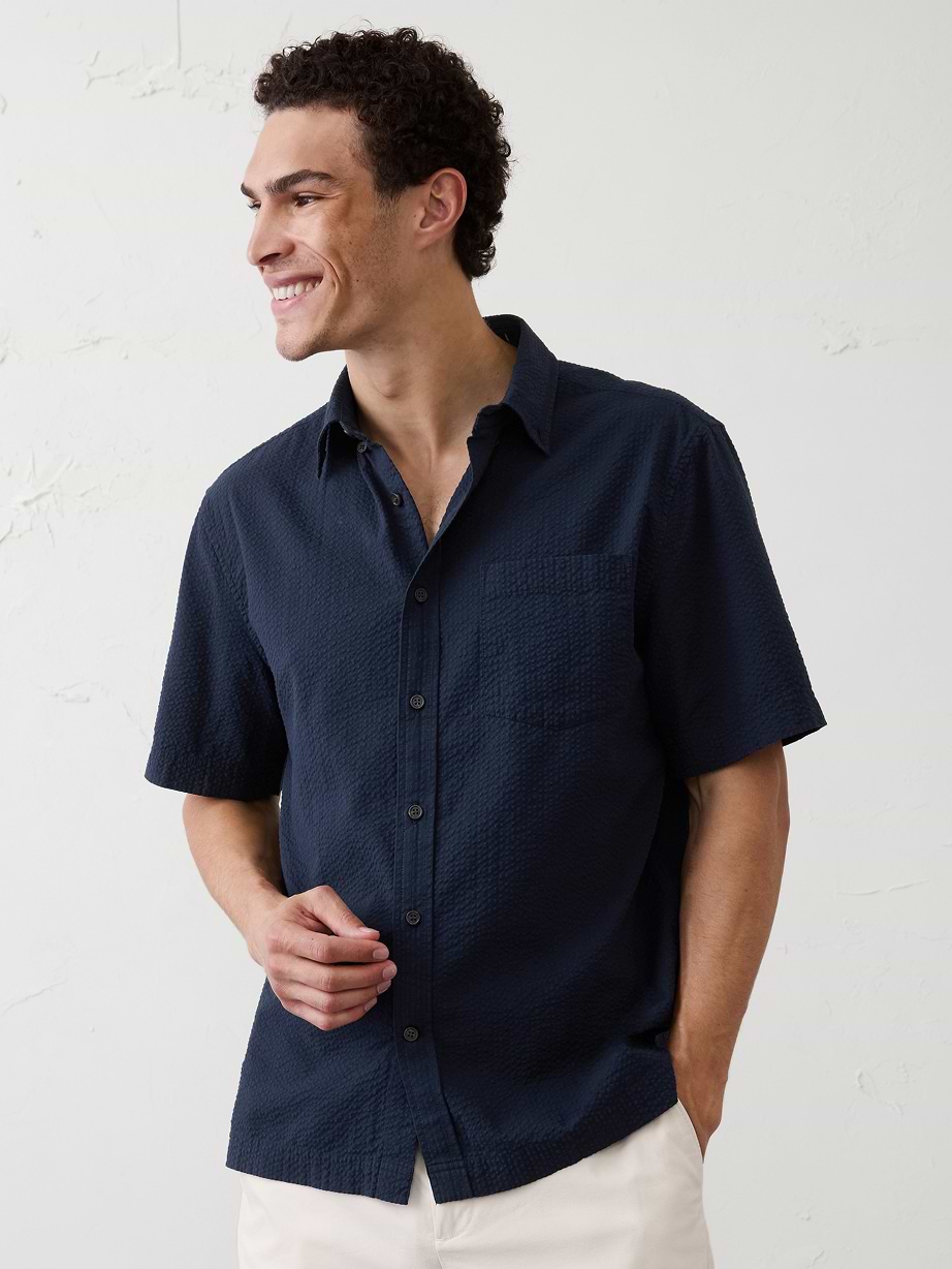 Man in blue shirt and white shorts.