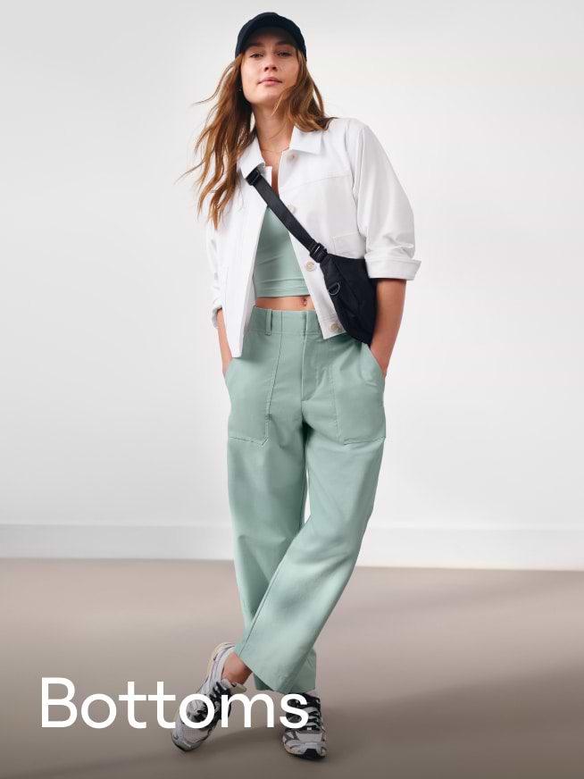 a woman in a white hat and black jacket standing in a room