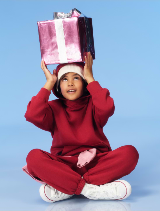 Image of a young model wearing a red fleece sweatshirt and sweatpants.