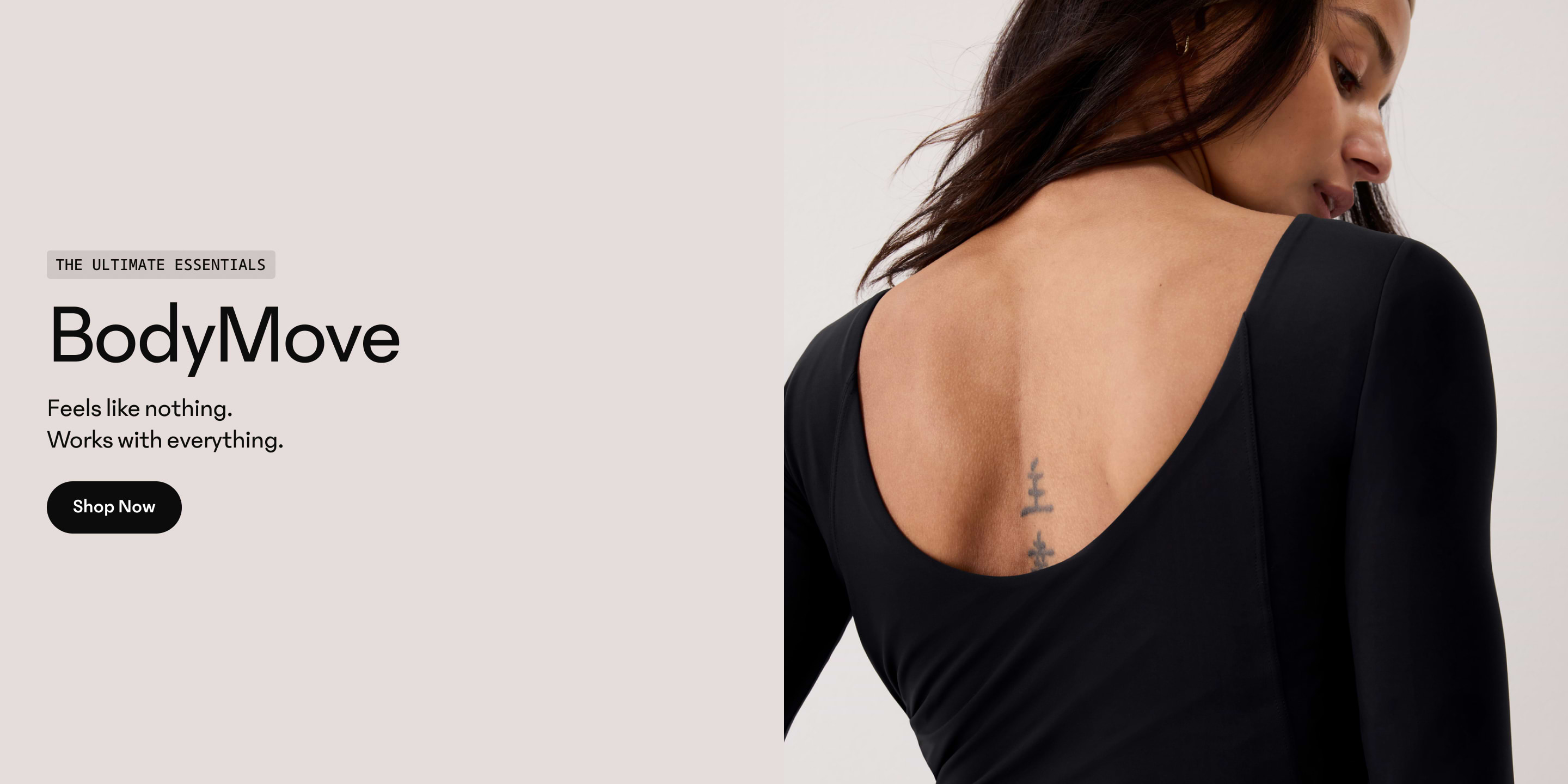 Back view of person in a black scoop-back top with a small spine tattoo.