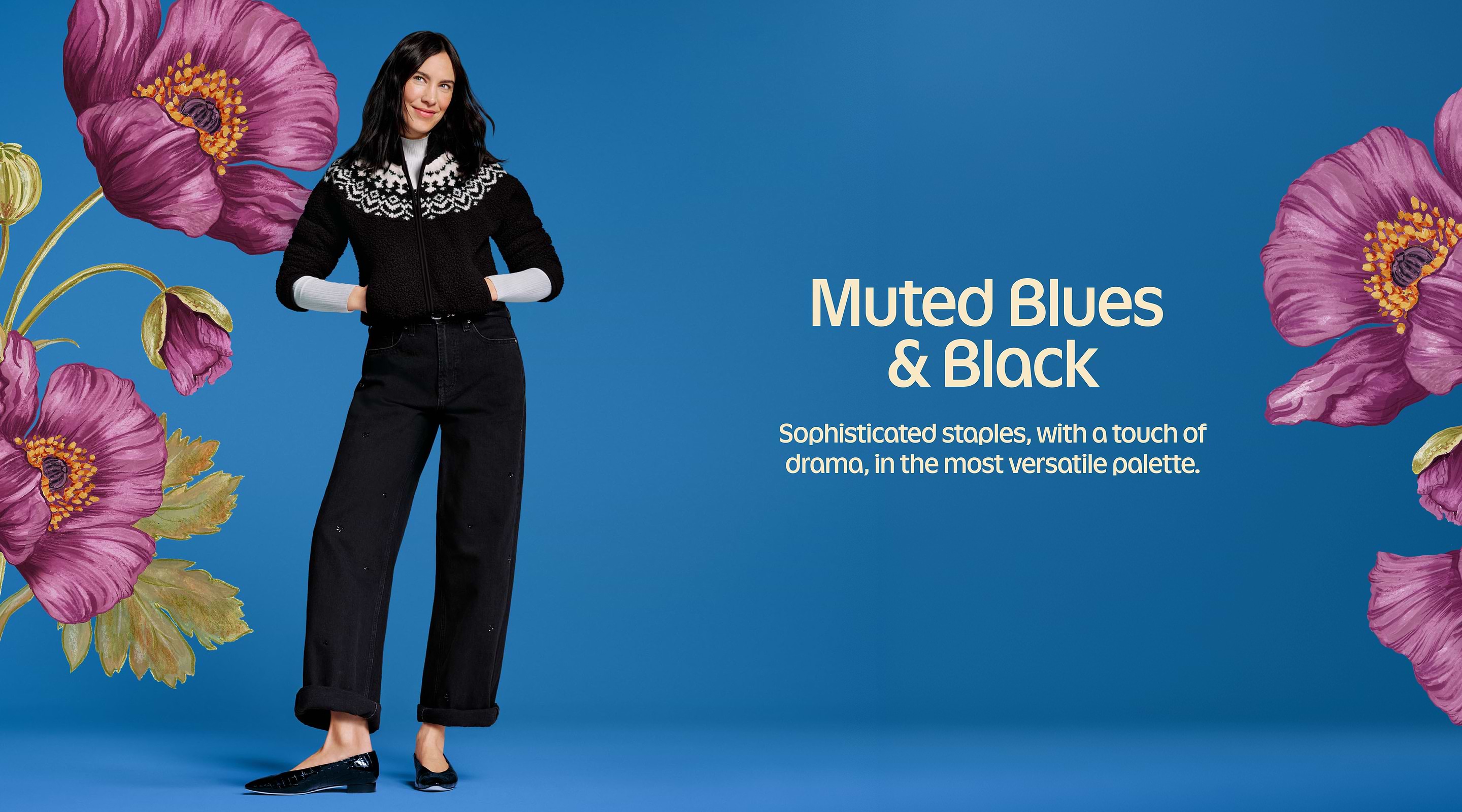 Model in a black‑and‑white patterned sweater and black wide‑leg jeans stands against a blue backdrop with large purple flowers; headline text reads “Muted Blues & Black.”