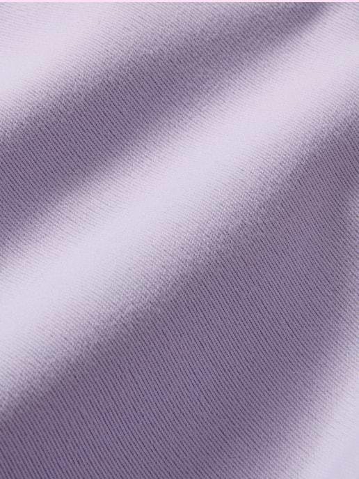 Close-up of light lavender fabric with fine ribbed texture and soft folds.