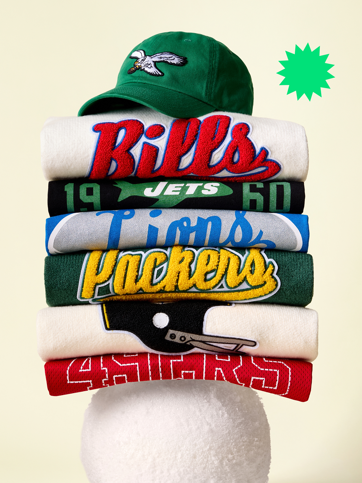 a stack of jerseys with a hat on top of them