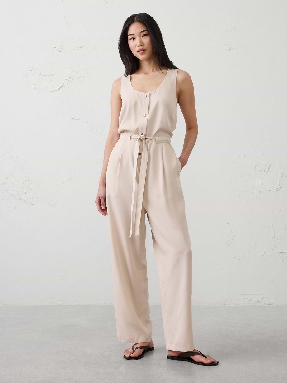Woman in tan linen jumpsuit.