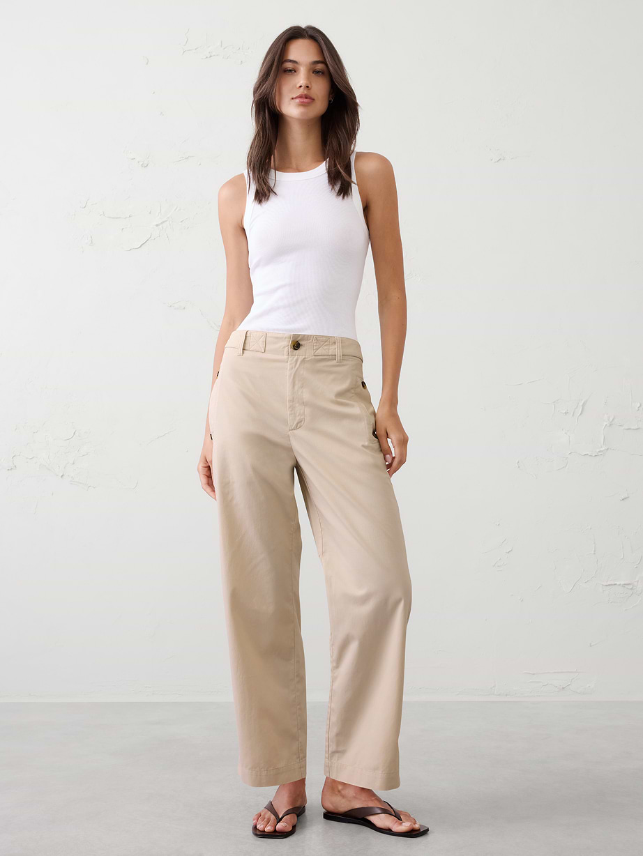 Woman in white tank top and khaki pants.