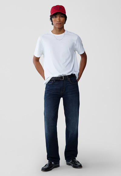 A male model wearing loose jeans and a jean jacket.