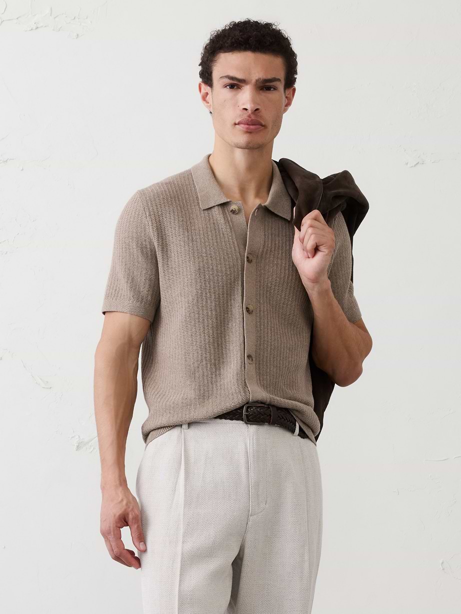 Man in tan sweater shirt and white pants.