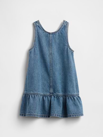 Back view of a sleeveless blue denim dress with a drop-waist ruffle hem.