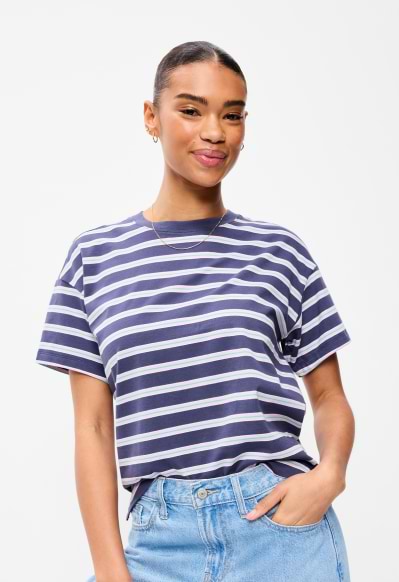 A female model wearing a striped crew-neck T-shirt.