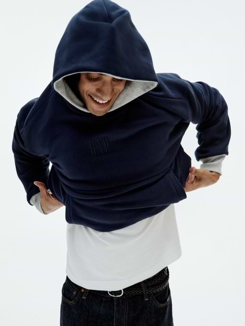 a man in a hoodie holding his phone to his ear