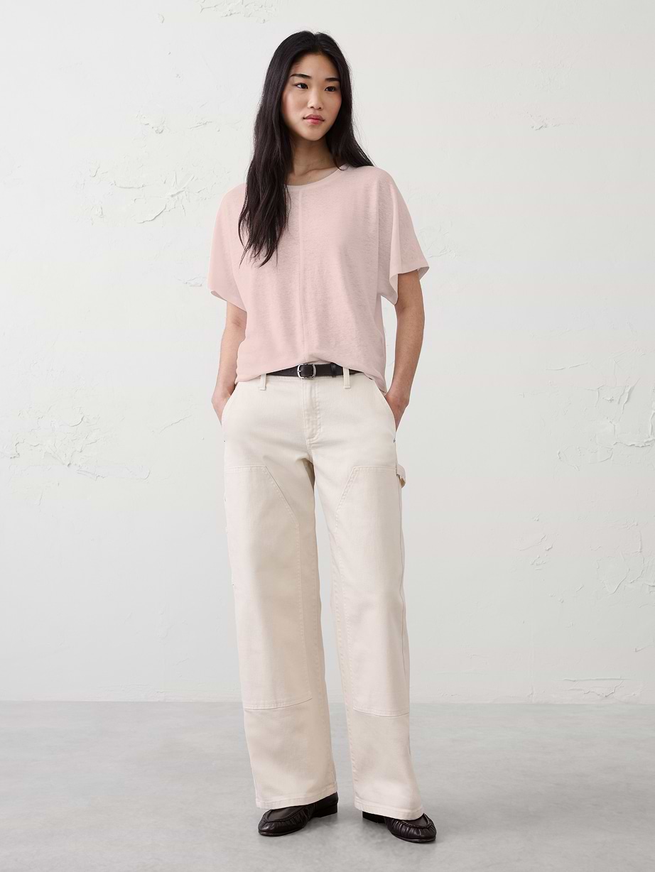 Woman in pink shirt and white pants.