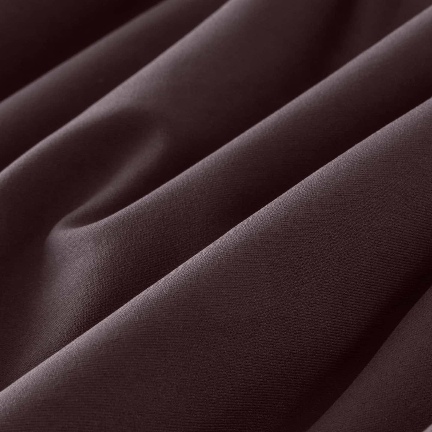 Close-up of dark brown fabric with soft diagonal folds and visible texture.