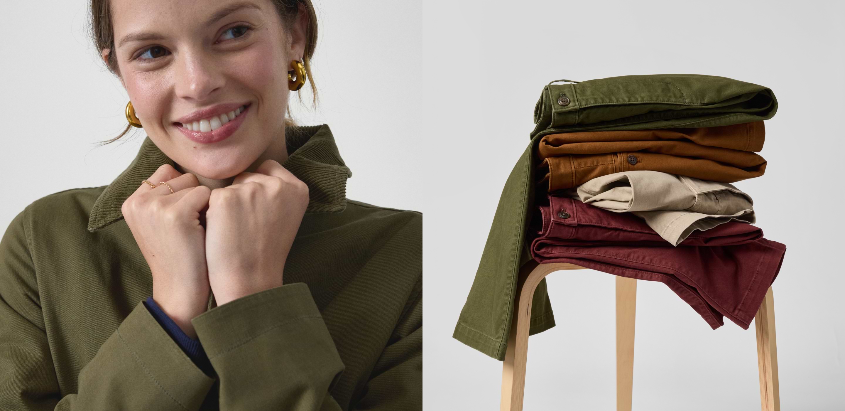 Smiling person in an olive jacket; beside them, folded chinos in green, brown, beige, and burgundy on a wooden stool.