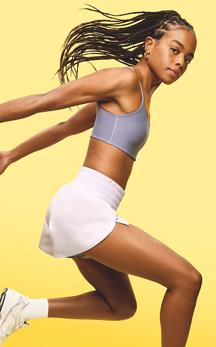 A female model wears a Light Support PowerSoft Rib Longline Sports Bra.