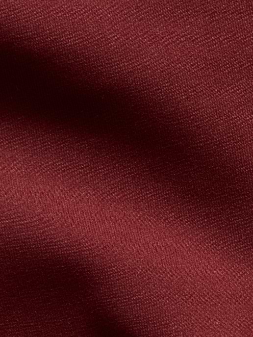 Close-up of burgundy fabric with soft, shadowed folds.